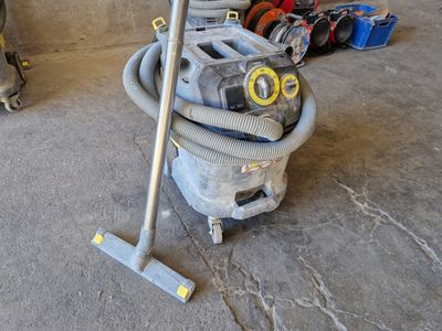 un aspirateur posé sur le sol à côté d'autres objets