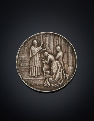 a silver coin with a woman and a man on it