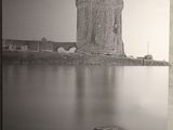 photographie en noir et blanc d'un château surplombant un plan d'eau