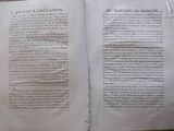 an open book on a table with a piece of paper on top of it