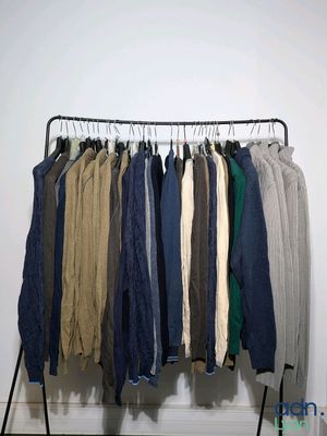 clothes hanging on a rack in front of a white wall