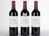 trois bouteilles de vin rouge posées l'une à côté de l'autre sur une surface blanche