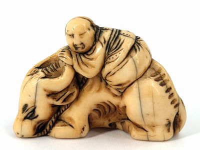 an image of a carved ivory figurine of a man and a dog