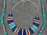 a necklace made with turquoise, red and silver beads
