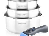 trois casseroles en acier inoxydable et une spatule bleue sur fond blanc