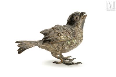 un oiseau argenté posé sur une surface blanche
