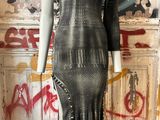a mannequin in front of a wall with graffiti on it