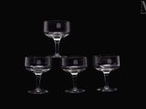 trois verres à vin vides empilés les uns sur les autres devant un fond noir