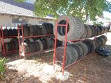 many tires stacked on a rack in front of a house
