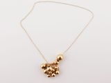 a gold teddy bear necklace on a gold chain