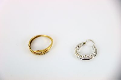 two gold and silver rings sitting next to each other on a white surface