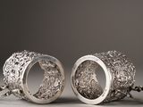 two silver rings with a chain hanging from them on a gray surface