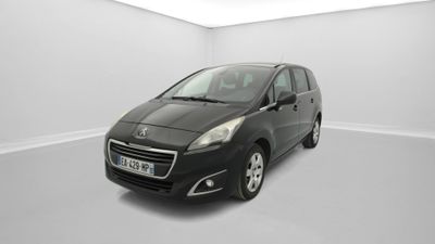 La petite voiture noire est garée dans une pièce blanche.