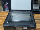 a black printer sitting on a wooden table next to a television