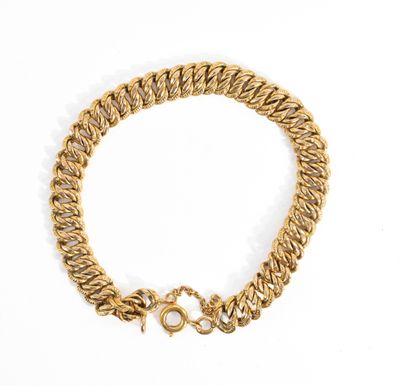 gros plan d'un bracelet en or sur fond blanc