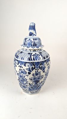 un vase bleu et blanc avec un couvercle posé sur une table
