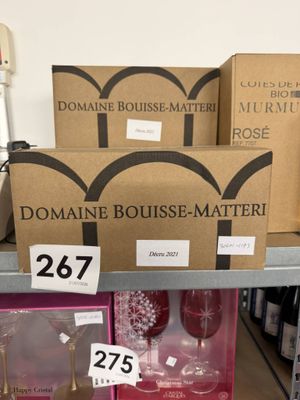 boxes of wine and wine glasses on a shelf in a store