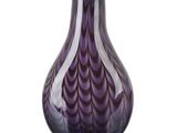 un vase violet posé sur une surface blanche