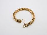 a gold chain bracelet with a clasp on a white background