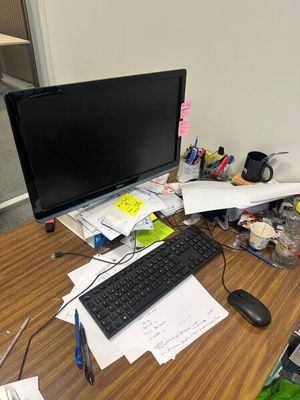 un bureau sur lequel se trouvent un ordinateur, un clavier, une souris et des papiers