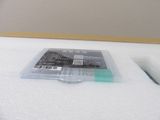 a small plastic container with a plastic lid on top of a bed