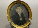 a miniature picture of a man in a suit on a stand