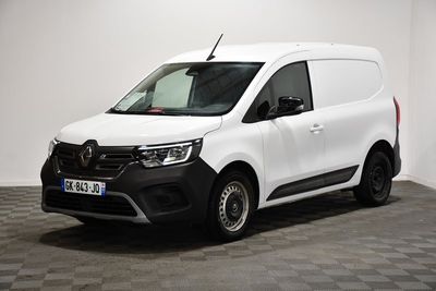La camionnette blanche est garée dans une pièce au sol carrelé en damier.