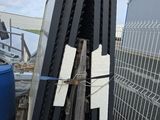 plusieurs morceaux de bois sont empilés les uns sur les autres devant une clôture