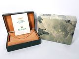 a rolex watch in a box with a card in it