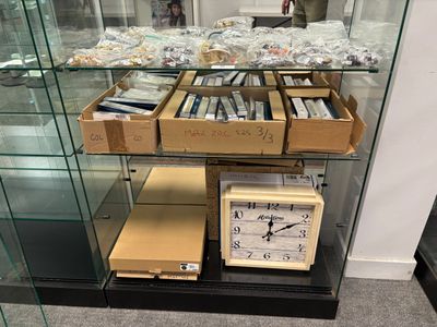 une vitrine sur laquelle sont posés une horloge et des boîtes