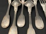six silver spoons and a fork on a black surface