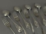 a lot of silver spoons and forks on the table