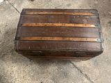 an old trunk sitting on the ground outside
