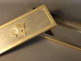 a gold box with a bird on it sitting on a table