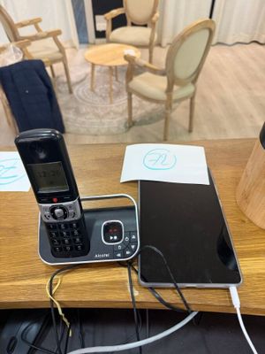 a cell phone sitting on top of a desk next to a laptop