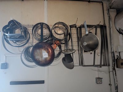 de nombreuses casseroles et poêles accrochées au mur