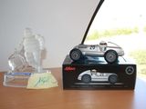 a toy car sitting on top of a table next to a glass figurine