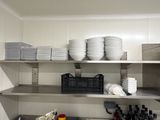 beaucoup d'assiettes et de bols sur les étagères de la cuisine