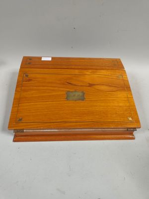 an old wooden box with a label on it sitting on a white surface