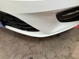 a close up of a white car parked in a parking lot