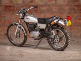 a silver motorcycle parked in front of a brick wall