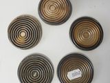 four black and gold metal knobs with a label on them