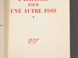 an open book with red writing on it sitting on top of a table