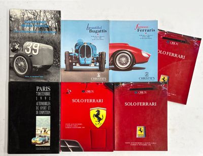 plusieurs livres posés sur une table blanche, avec une voiture rouge et une voiture noire