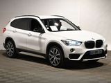 the bmw x1 is parked in a garage with a checkered floor