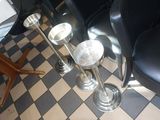 deux vases en argent posés sur le sol à carreaux d'un restaurant