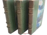 trois livres alignés sur une surface blanche