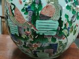a vase with a bird on it sitting on a table