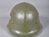 Le casque est vert, avec des rayures rouges, blanches et vertes.