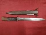 an old knife and a small knife on a red cloth